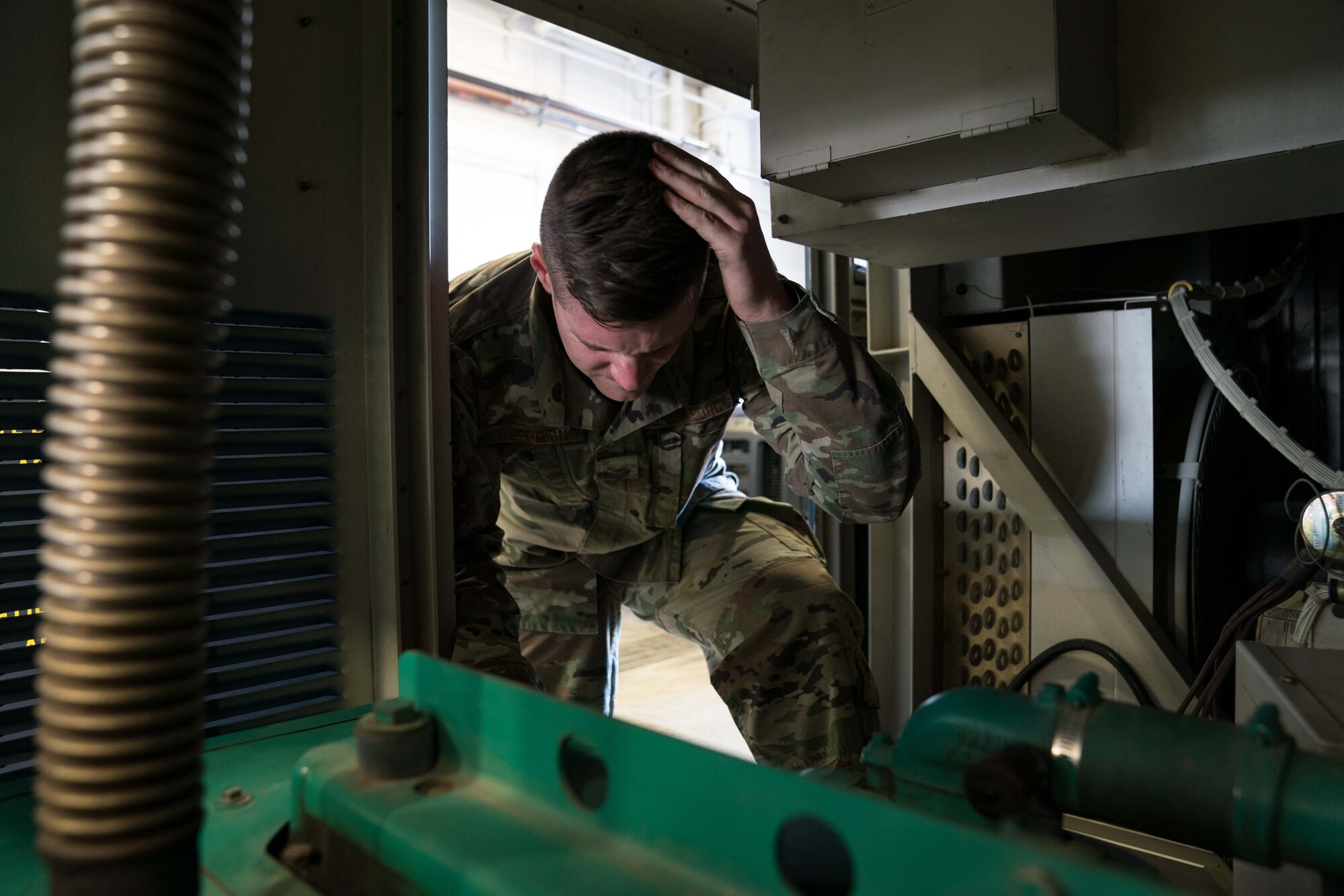 Senior Airman Justin Harrison, 90th Missile Maintenance Squadron, Facility Maintenance Section, support section supervisor, hits his head while performing maintenance on a portable air condition unit on F.E. Warren AFB, Wyoming, Nov. 18, 2019. Tech. Sgt. Haisen Exon, 90 MMXS/FMS, support section NCOIC, teams up with the 90th Missile Wing LaunchWerx agency to bring forward an idea to prevent future head injuries across the wing. (U.S. Air Force photo by Joseph Coslett)