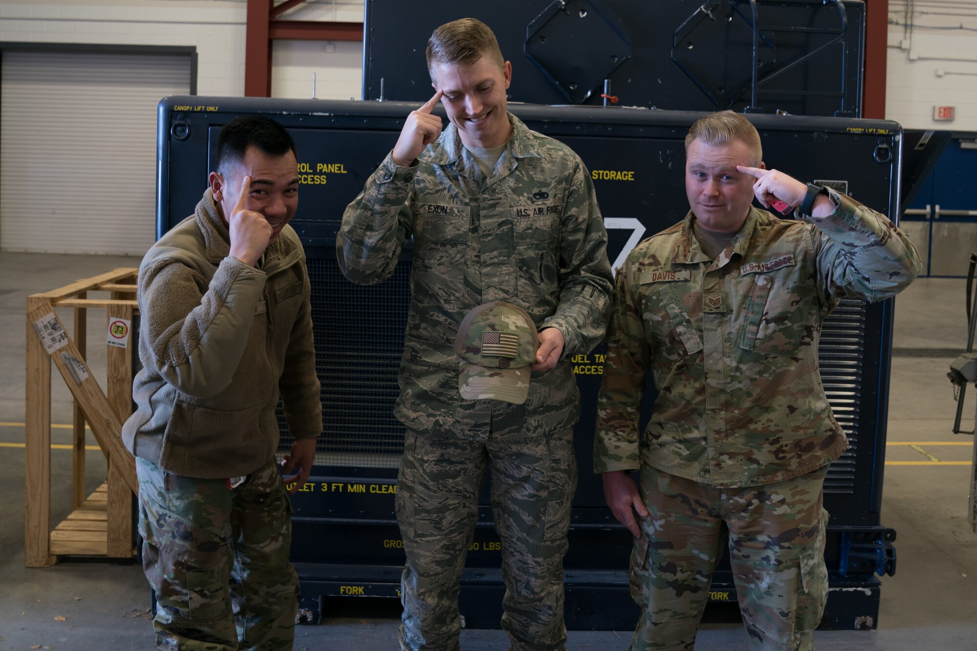 Tech. Sgt. Ferdie Galicia and Tech. Sgt. Haisen Exon, 90th Missile Maintenance Squadron, Facilities Maintenance Section,  and Staff Sgt. Kolby Davis, 90th Missile Wing LaunchWERX innovation specialist, gesture to think of good ideas to improve the unit on F.E. Warren AFB, Wyoming, Nov. 18, 2019. They team up to launch a new bump cap initiative to prevent future head injuries across the wing. (U.S. Air Force photo by Joseph Coslett)