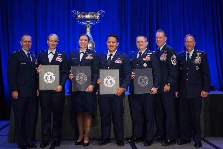 Seven people standing on a stage.
