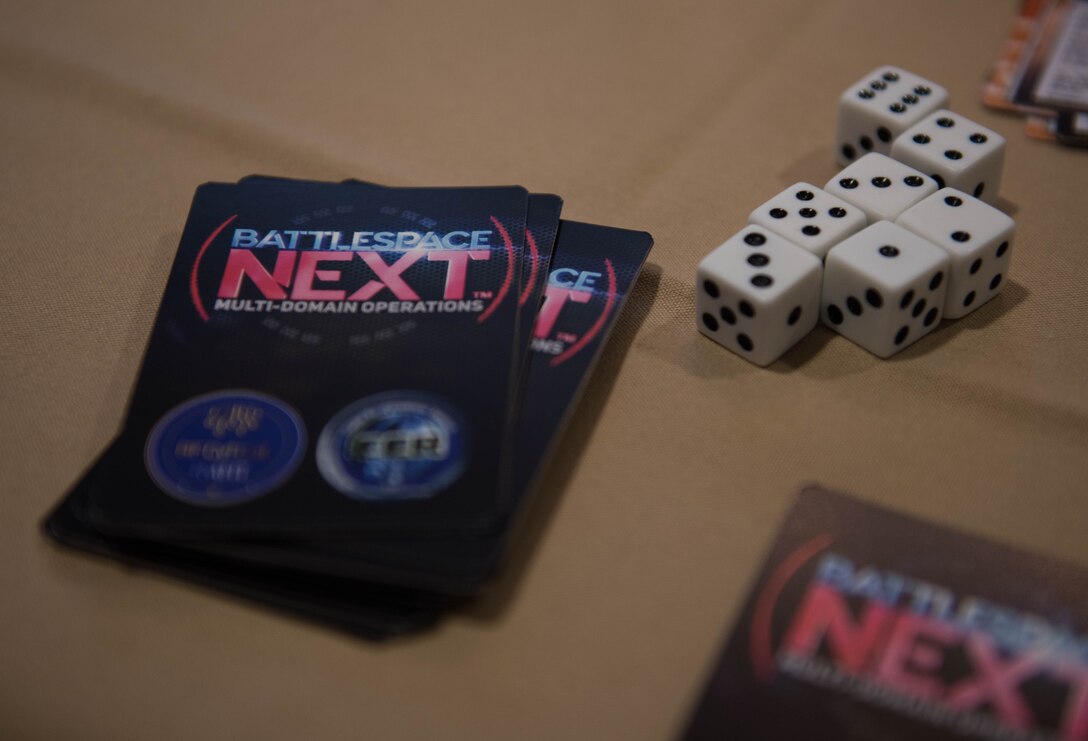 A deck of Battlespace Next cards and dice sit on a table at Joint Base Langley-Eustis, Virginia, Nov. 18, 2019. U.S. Air Force Capt. Nathaniel Flack, Department of Electrical and computer engineering student at the Air Force Institute of Technology, created the game for Airmen to become familiar with modern day issues in a different type of learning environment. (U.S. Air Force photo by Airman 1st Class Sarah Dowe)