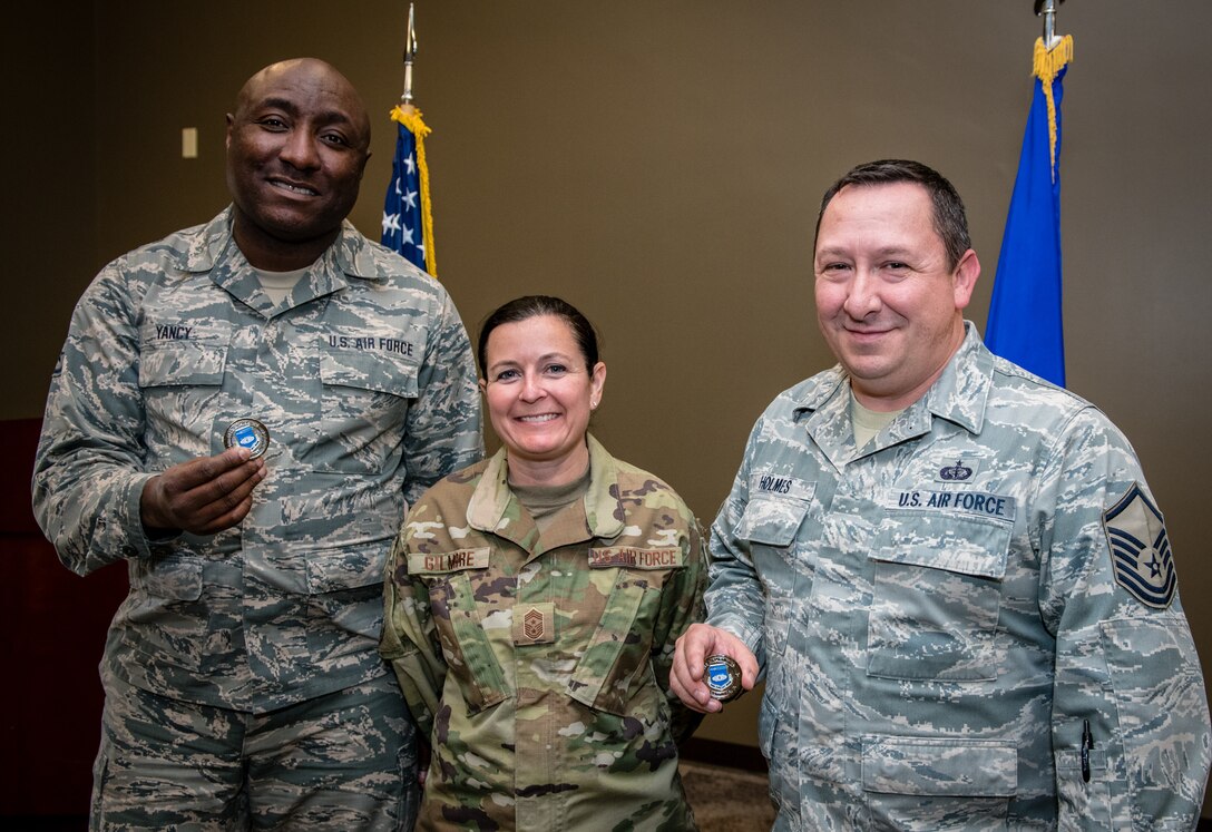 Retiring 932nd Force Support Squadron members, Master Sgt. Jeffery Holmes, right, and Staff Sgt. Germaine Yancy left pose with the 932nd Airlift Wing Command Chief, Barbara Gilmore following a combined coin presentation Nov. 16, 2019, Scott Air Force Base, Illinois.  Gilmore thanked the retiring NCOs for their service and work within the 932nd FSS.  Between Holmes and Yancy they have more than 54 years of military service, with Yancy having served in the Marines, Navy, Air National Guard and the Air Force Reserve. (U.S. Air Force photo by Master Sgt. Christopher Parr)
