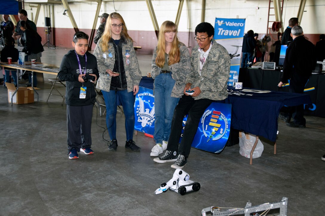 Lukas Carrillo tries his hand at using a robot with the from Virginia Allred Stacey Junior Senior High School Bots in Blue robotics team during the Youth Aerospace Expo at Kelly Field, Texas, Nov. 16, 2019.
