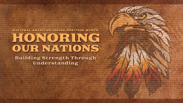 The Department of Defense 2019 National American Indian Heritage Month poster depicts an auburn and brown background of varying shades. At the top of the poster is a medium-dark brown header. The names of the 573 Indian and Alaskan federally recognized tribes maintained by the Bureau of Indian Affairs, Department of the Interior fills the entire background of the poster in dark brown text. These tribal names can be seen through all the lettering on the poster as well as the primary image at the center.
Imposed on the medium-dark brown header is the observance theme “Honoring Our Nations, Building Strength through Understanding” in lighter auburn colored text.
Immediately below the theme and on the auburn-brown background is the observance title spread across two lines. The first line in smaller capitalized block text reflects, NATIONAL AMERICAN INDIAN. Immediately below in larger font is the remainder of the title, HERITAGE MONTH.