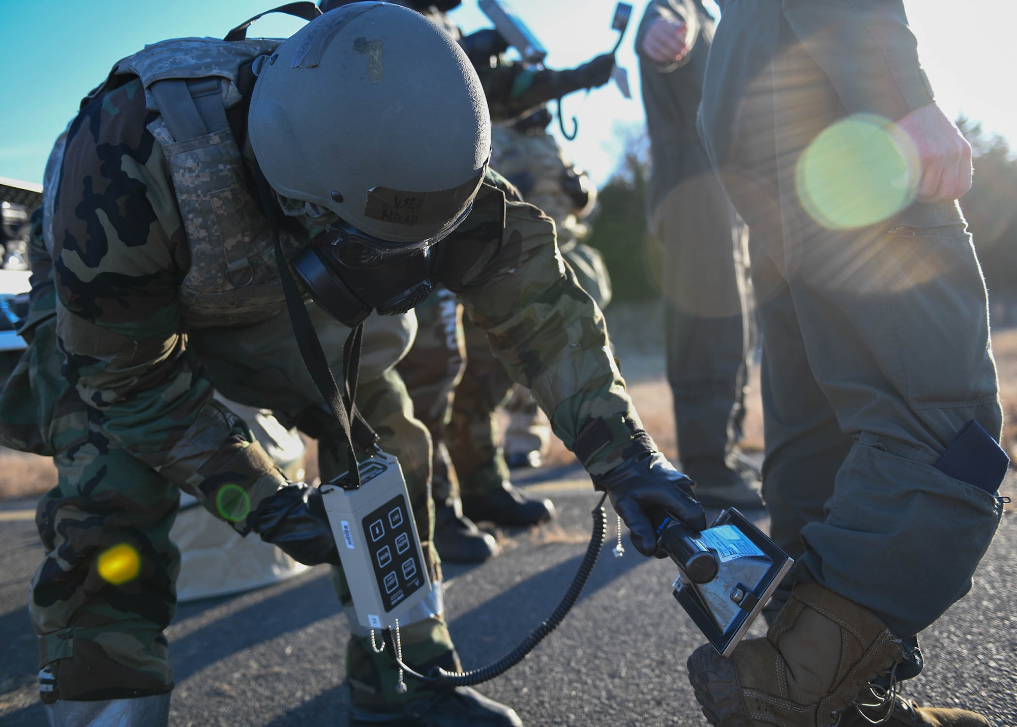 An airman uses a tool to scan for radiation