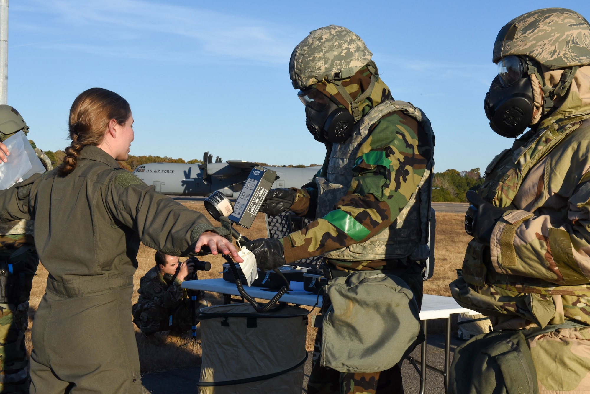 An airman uses a tool to scan for radiation
