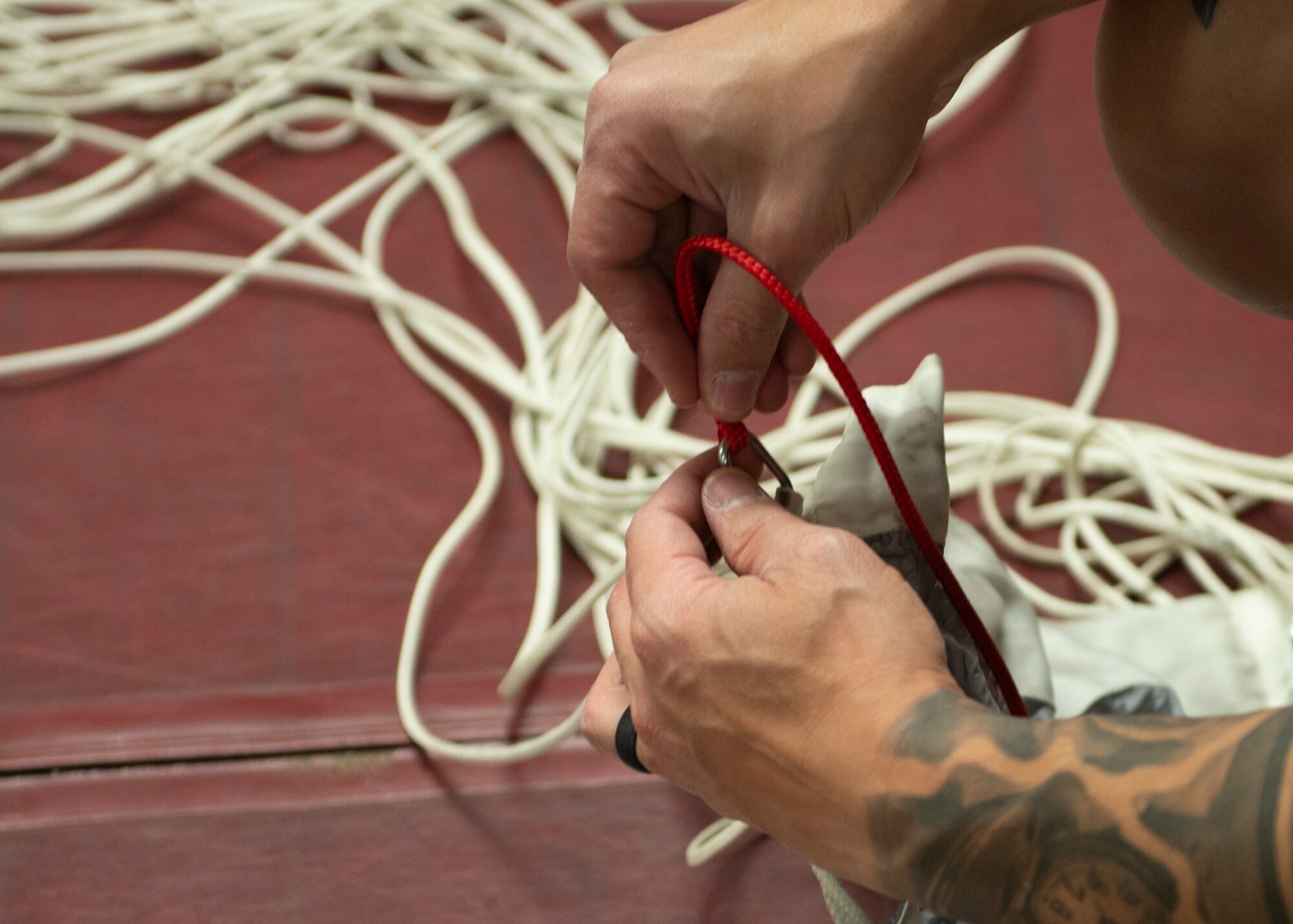 Alaska Air National Guard Tech. Sgt. Eduardo Peguero, 176th Operations Support Squadron aircrew flight equipment technician, converts a freefall parachute to a static line configuration at Joint Base Elmendorf-Richardson, Alaska, Nov. 14, 2019. The AFE Guardian Angel Section supports Alaska’s rescue mission by preparing parachutes and maintaining the equipment needed to deploy pararescuemen as an emergency response.