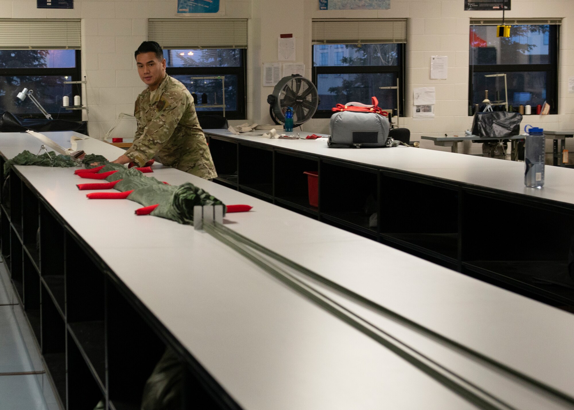 Alaska Air National Guard Tech. Sgt. Ferdie Villaflores, 176th Operations Support Squadron aircrew flight equipment technician, inspects a parachute at Joint Base Elmendorf-Richardson, Alaska, Nov. 14, 2019. The AFE Guardian Angel Section supports Alaska’s rescue mission by preparing parachutes and maintaining the equipment needed to deploy pararescuemen as an emergency response.