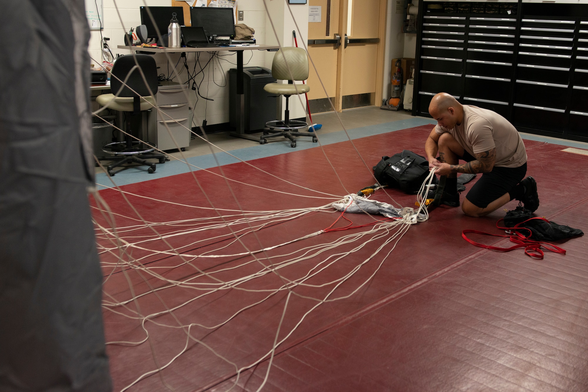 Alaska Air National Guard Tech. Sgt. Eduardo Peguero, 176th Operations Support Squadron aircrew flight equipment technician, checks the lines on a parachute at Joint Base Elmendorf-Richardson, Alaska, Nov. 14, 2019. The AFE Guardian Angel Section supports Alaska’s rescue mission by preparing parachutes and maintaining the equipment needed to deploy pararescuemen as an emergency response.