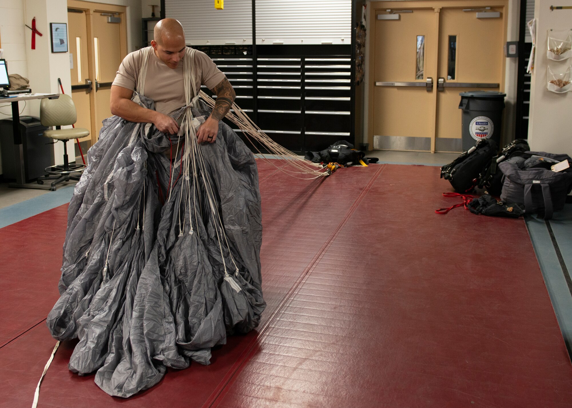 Alaska Air National Guard Tech. Sgt. Eduardo Peguero, 176th Operations Support Squadron aircrew flight equipment technician, packs a parachute at Joint Base Elmendorf-Richardson, Alaska, Nov. 14, 2019. The AFE Guardian Angel Section supports Alaska’s rescue mission by preparing parachutes and maintaining the equipment needed to deploy pararescuemen as an emergency response.