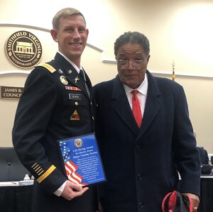 U.S. Army Maj. Timothy Decker, operations officer for the U.S. Army Center for Initial Military Training, poses for a picture with George Gray in Smithfield, Va., Nov. 5, 2019. Decker was presented the Life Saving Award by the Smithfield Police Department for saving the life of Gray, 82, after his boat capsized in the Pagan River.