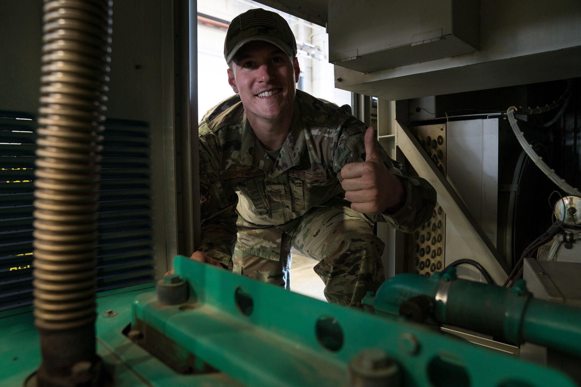 Senior Airman Justin Harrison, 90th Missile Maintenance Squadron, Facility Maintenance Section, support section supervisor, shows how the bump cap can prevent head injuries while performing maintenance on a portable air condition unit on F.E. Warren AFB, Wyoming, Nov. 18, 2019. Tech. Sgt. Haisen Exon, 90 MMXS/FMS, support section NCOIC, teams up with the 90th Missile Wing LaunchWerx agency to bring forward an idea to prevent future head injuries across the wing. (U.S. Air Force photo by Joseph Coslett)