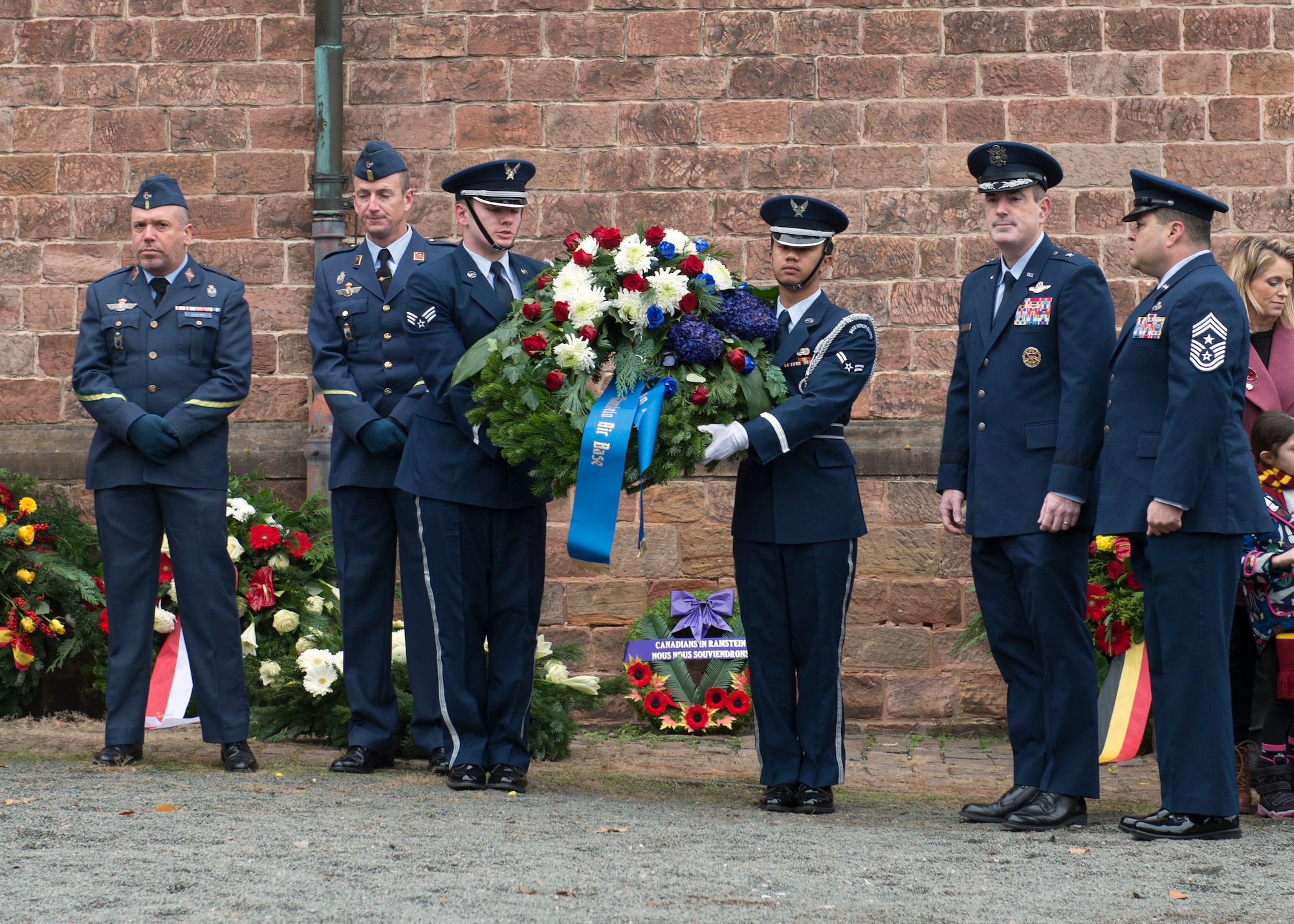 U.S. Air Force Brig. Gen. Mark R. August, 86th Airlift Wing commander, and U.S. Air Force Chief Master Sgt. Ernesto J. Rendon, 86th AW command chief, look on as members of the Ramstein Air Base Honor Guard prepare to lay a wreath during the Ramstein-Miesenbach’s National Day of Mourning Ceremony, Nov. 17, 2019.