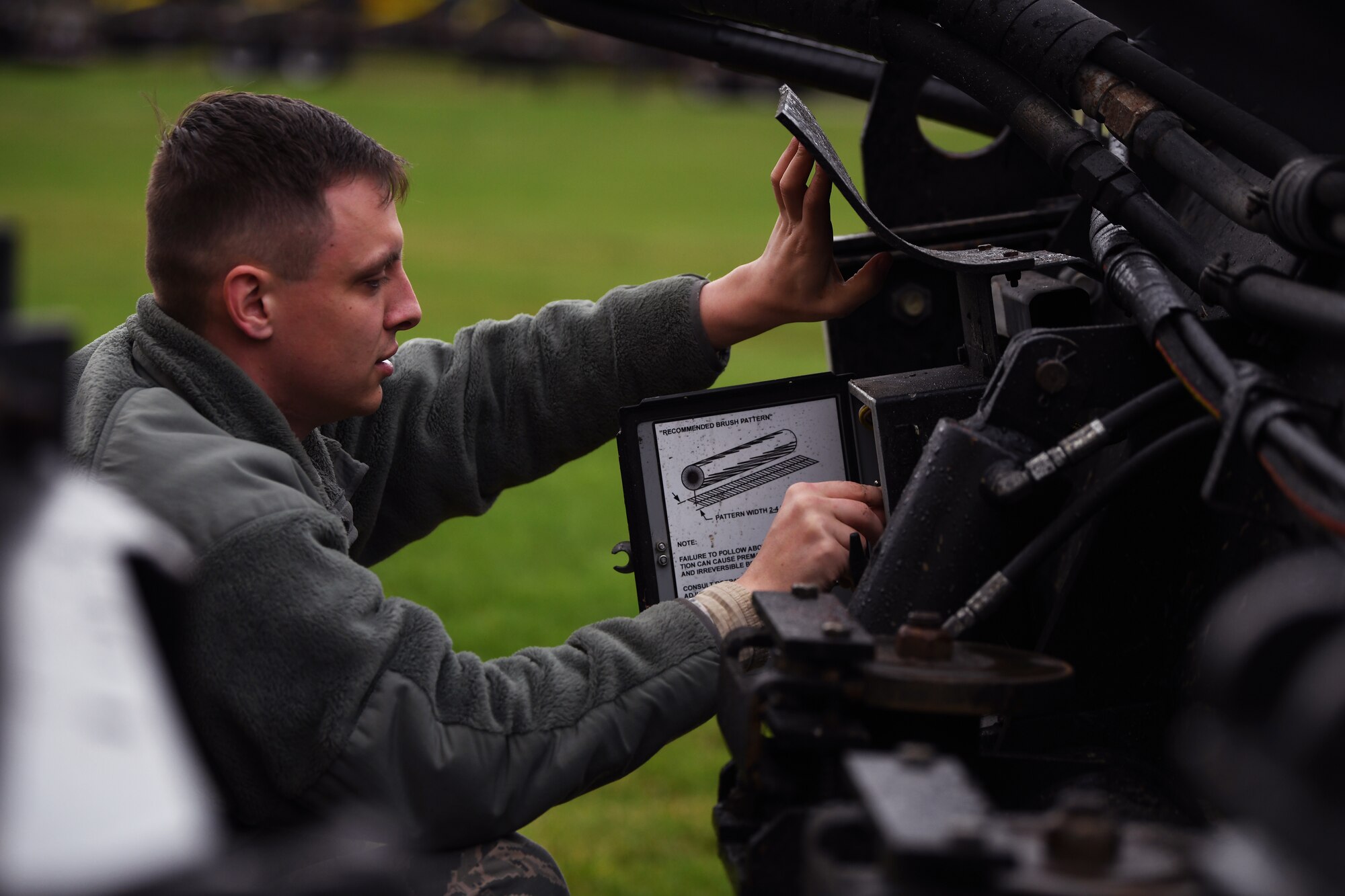 A 48th Civil Engineer Squadron pavement and construction Airman examines snow removal equipment during an event displaying snow and ice removal machines at Royal Air Force Lakenheath, England, Nov. 15, 2019. The 48th CES operates a fleet of 12 variations of multi-purpose snow plow machines to support the installation during inclement weather.  (U.S. Air Force photo by Senior Airman Shanice Williams-Jones)