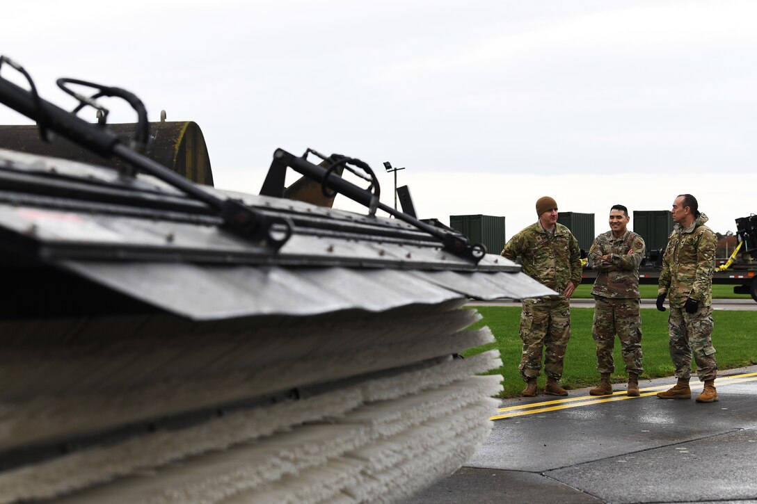 48th Civil Engineer Squadron leadership discuss mission readiness during an event displaying snow and ice removal machines at Royal Air Force Lakenheath, England, Nov. 15, 2019. The 48th CES operates a fleet of 12 variations of multi-purpose snow plow machines to support the installation during inclement weather.  (U.S. Air Force photo by Senior Airman Shanice Williams-Jones)