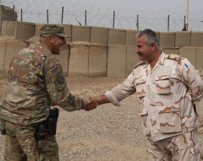 Col. Ali Husayen Abdallah Aljaf, officer-in-charge of Iraq Army Transportation Brigade, shakes hands with U.S. Army Capt. Alfred Vidrio, procurement project officer-in-charge of supply and service of the 108th Sustainment Brigade, at a collection point for tactical and non-tactical vehicles repair parts near Camp Taji, Iraq, Oct. 21, 2019. Task Force Lincoln’s divestment is one of the first divestments where the Iraqi military will go through the Iraq Army logistic system that will increase self-sufficiency in transporting spare parts and equipment. (U.S. Army photo by Capt. Karla M. Crayne)