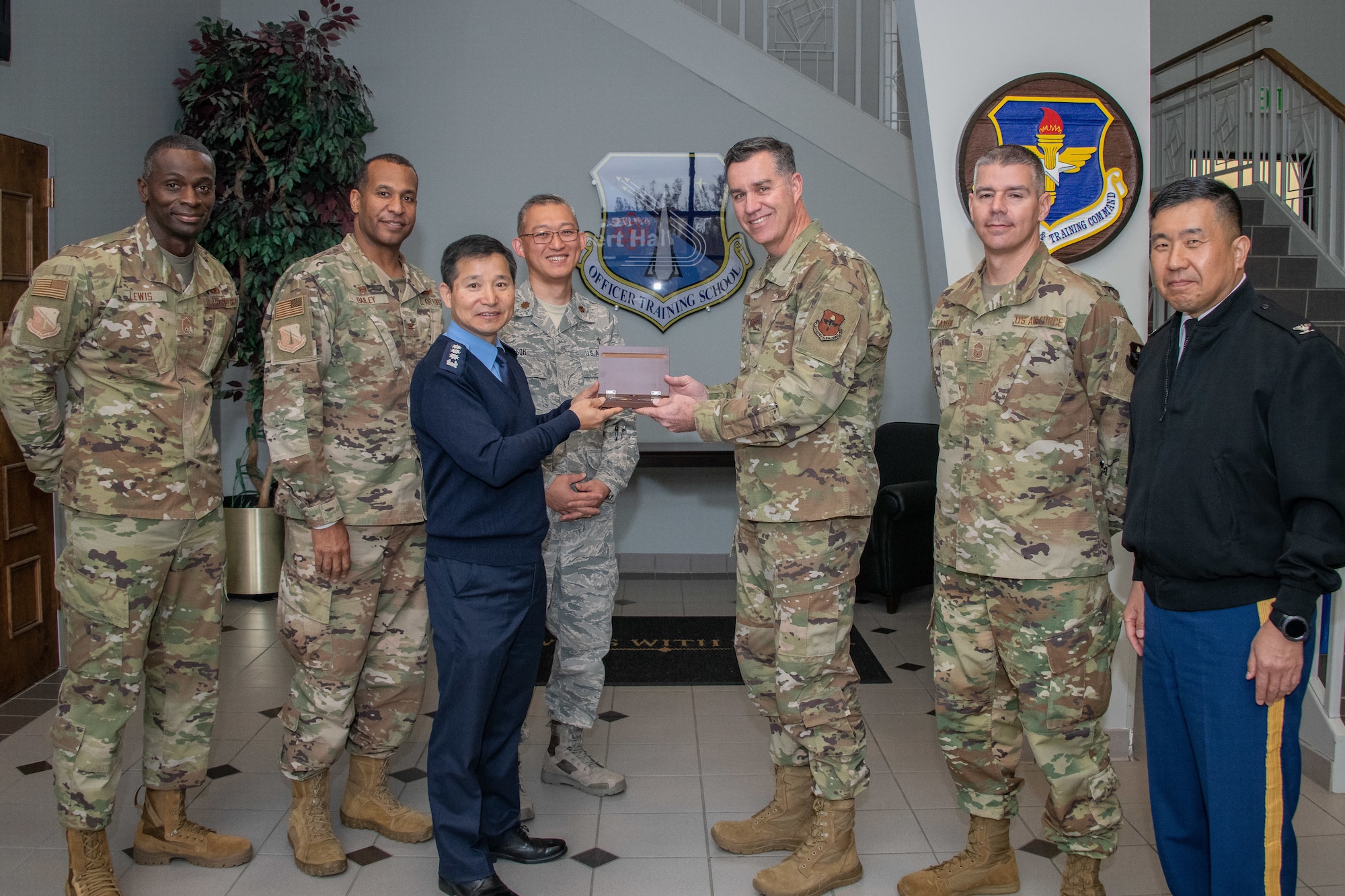 Chaplain, Col. Kwang-Nam Na, Republic of Korea Air Force Chief of Chaplains, and Chaplain, Col. Michael Newton, Air Force Chaplain Corps Chief of Chaplains commandant, extend mutual tokens of appreciation during a visit to Air University Nov. 13-15, 2019, at Maxwell, Air Force Base, Alabama. The visit, as a whole, was held to signify their commitment to strengthening national and functional alliances in support of the Secretary of the Air Force’s priorities. Also included in the photo are (left to right) Chief Master Sgt. Gabriel Lewis, Officer Training School superintendent, Col. Peter Bailey, OTS commandant, Chaplain, Maj. Shin Soh, ROKAF translator, Chief Master Sgt. Michael Taylor, AFCCC chief, Chaplain, Col. Samuel Lee, United Nations Command, Combined Forces Command and United States Forces Korea Command Chaplain.