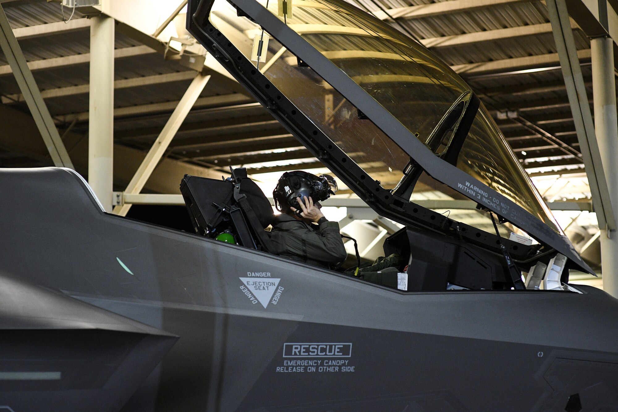 An F-35A pilot with the 388th Fighter Wing dons his helmet prior to launch at Hill Air Force Base, Utah on Nov. 13, 2019. The 34th Fighter Squadron departed Hill for Al Dhafra Air Base, United Arab Emirates, to support the United States Air Force Central Command mission in the MIddle East. The group of deploying Airmen was made up of pilots from the active duty 34th Fighter Squadron and Reserve 466th Fighter Squadron, as well as active duty and Reserve Airmen in the 34th Aircraft Maintenance Unit, and personnel in other support functions. (U.S. Air Force photo by R. Nial Bradshaw)