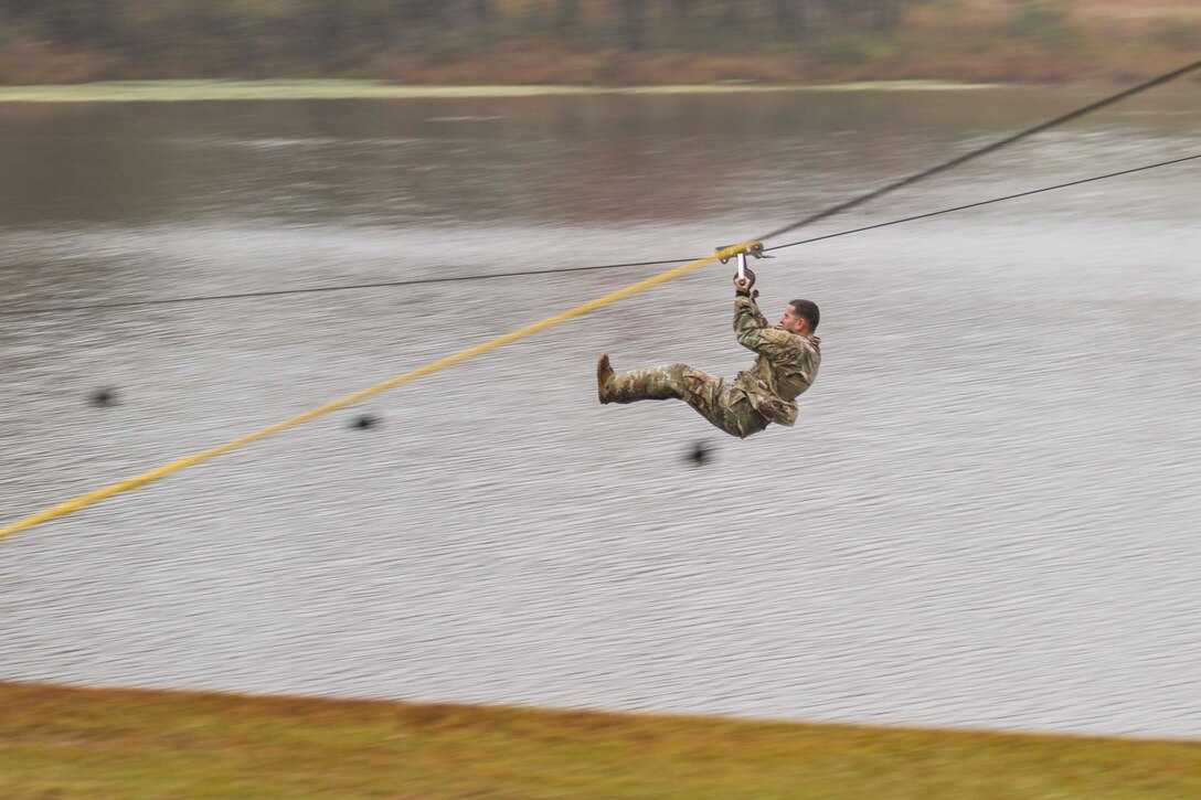 A soldier zip lines.