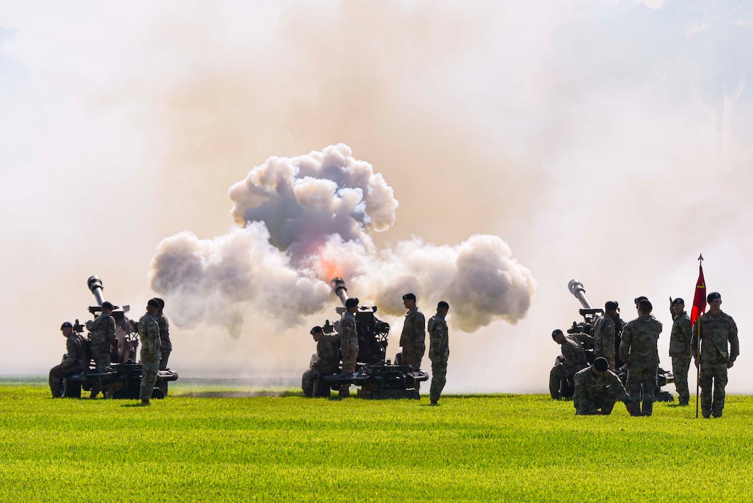 A group of soldiers fire cannons.