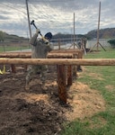 A West Virginia Army National Guard Soldier assigned to the 1092nd Engineer Battalion uses a mallet to drive a post into place to complete an obstacle course for the Sissonville High School Marine Corps Junior Reserve Officer Training Corps. Twelve engineers from the WVANRG completed the obstacle course project in one week as a part of an Innovative Readiness Training (IRT) program.