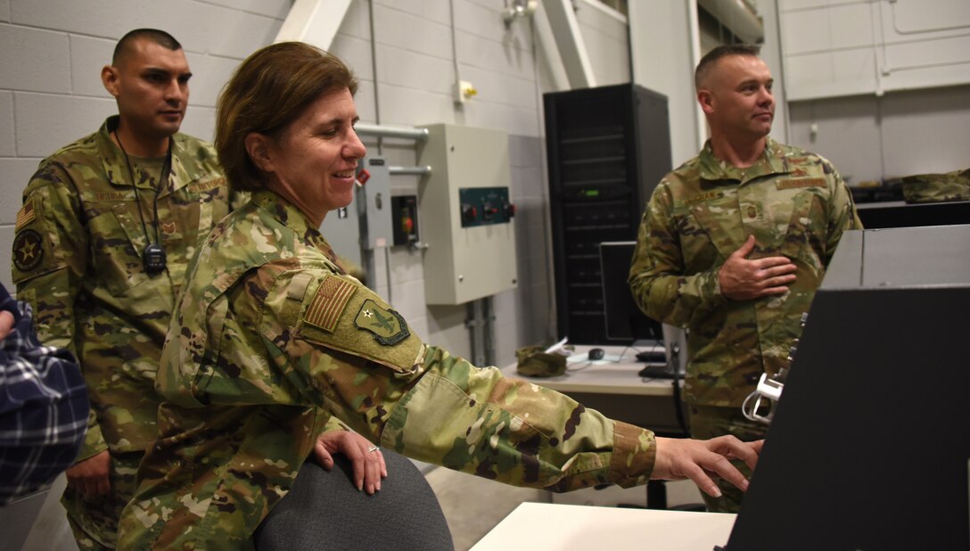 Second Air Force commander, presses a control to close the missile launcher on an F-22 Raptor training model at Sheppard Air Force Base, Texas