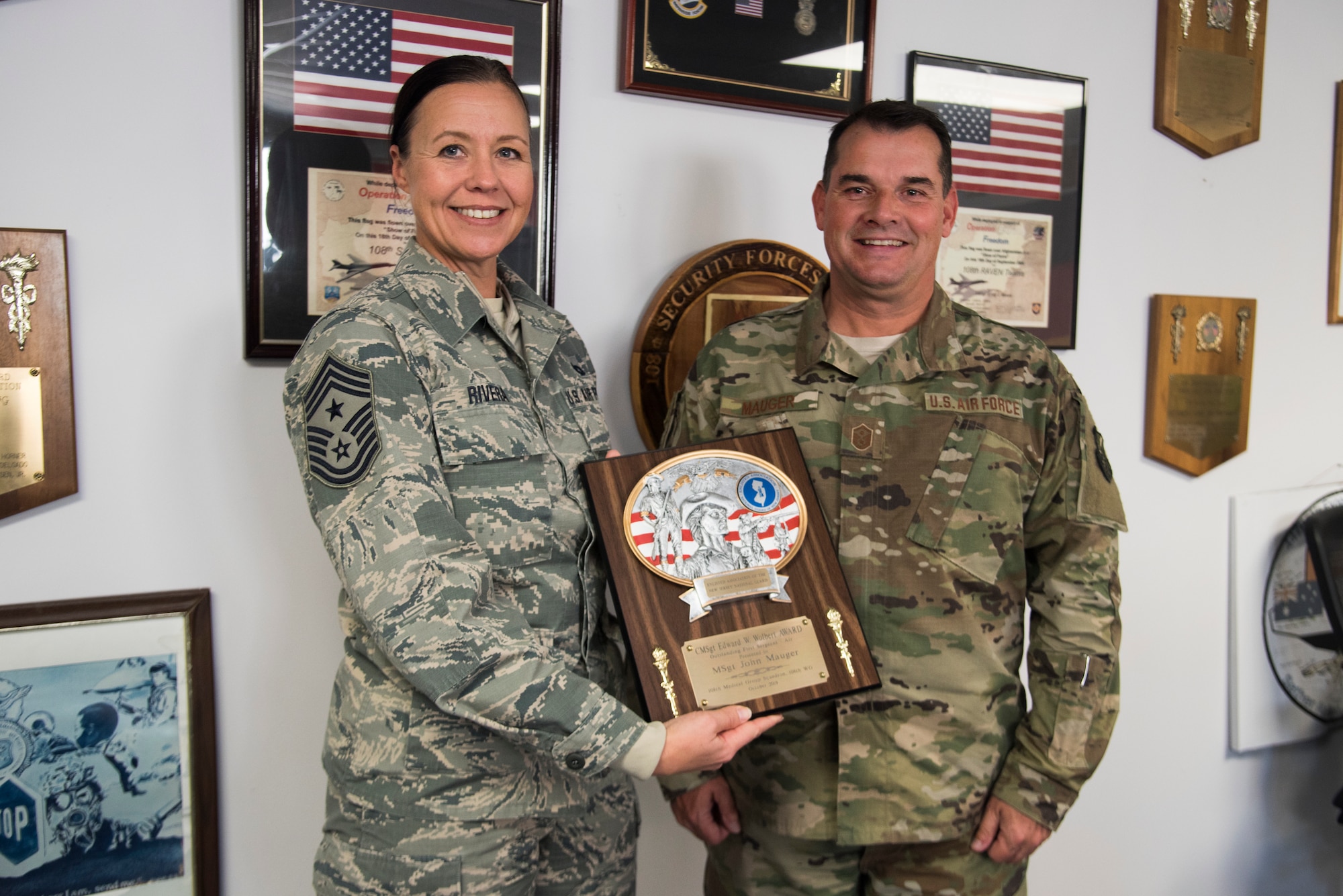 Command Chief Masfter Sgt. Holly R. RIvera, the 108th Wing command chief, left, presents the Chief Master Sgt. Edward W. Wolbert Oustanding First Sergeant Award to Master Sgt. John Mauger, the 108th Medical Group first sergeant, at Joint Base McGuire-Dix-Lakehurst, N.J., Nov. 16, 2019. Mauger was selected as the award winner on Aug. 9, 2019 by the Enlisted Association of the National Guard of New Jersey. (U.S. Air National Guard photo by Senior Airman Julia Santiago)