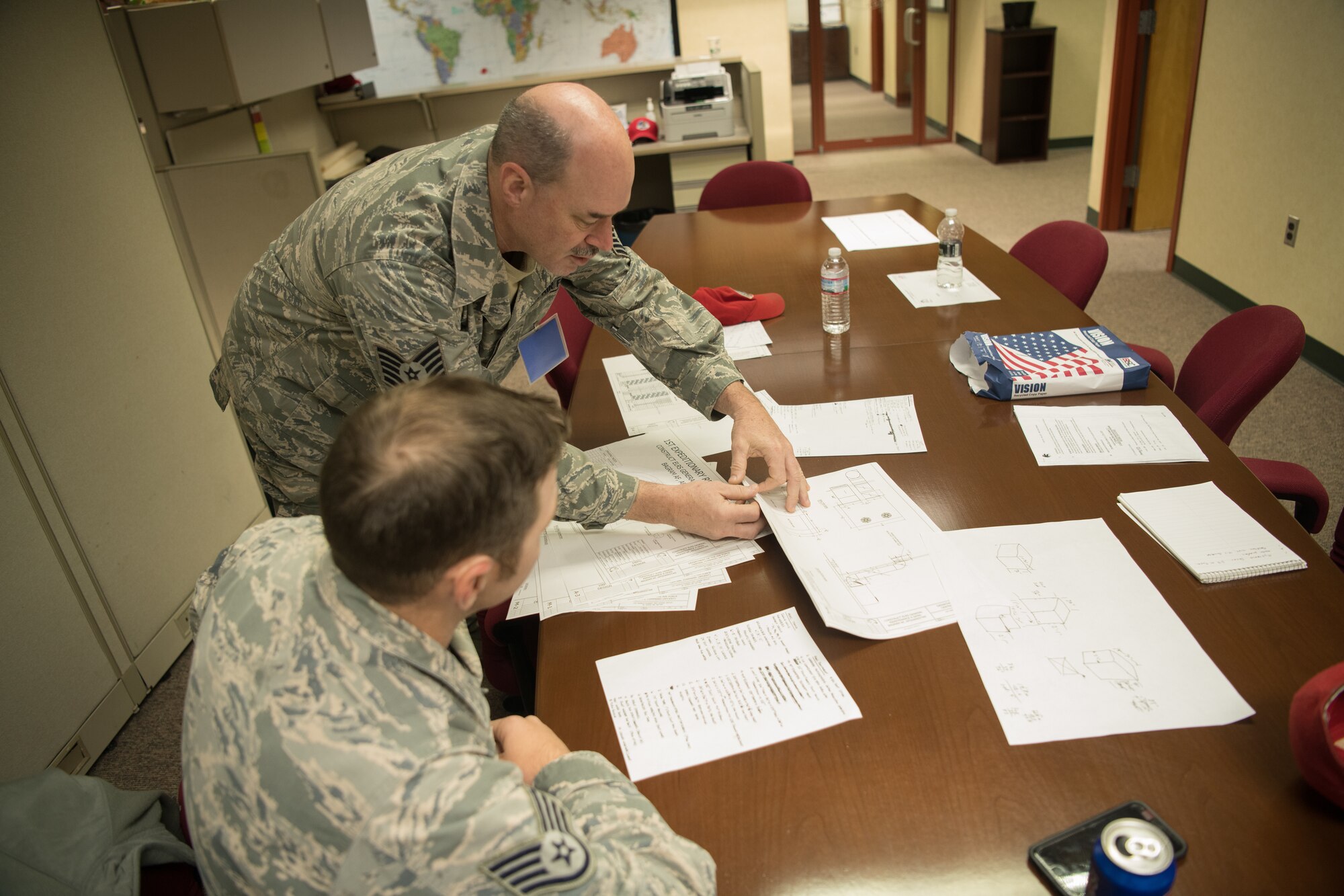 Two Airmen review building plans