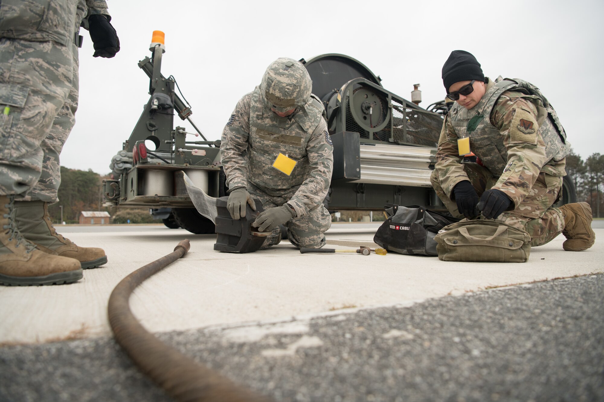 Three Airmen set up a mobile aircraft arrest system