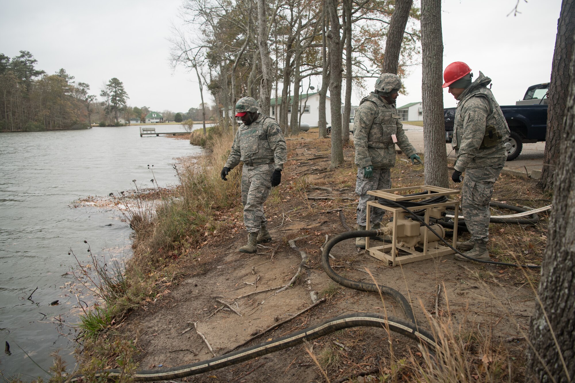 Three Airmen operate a water purification system
