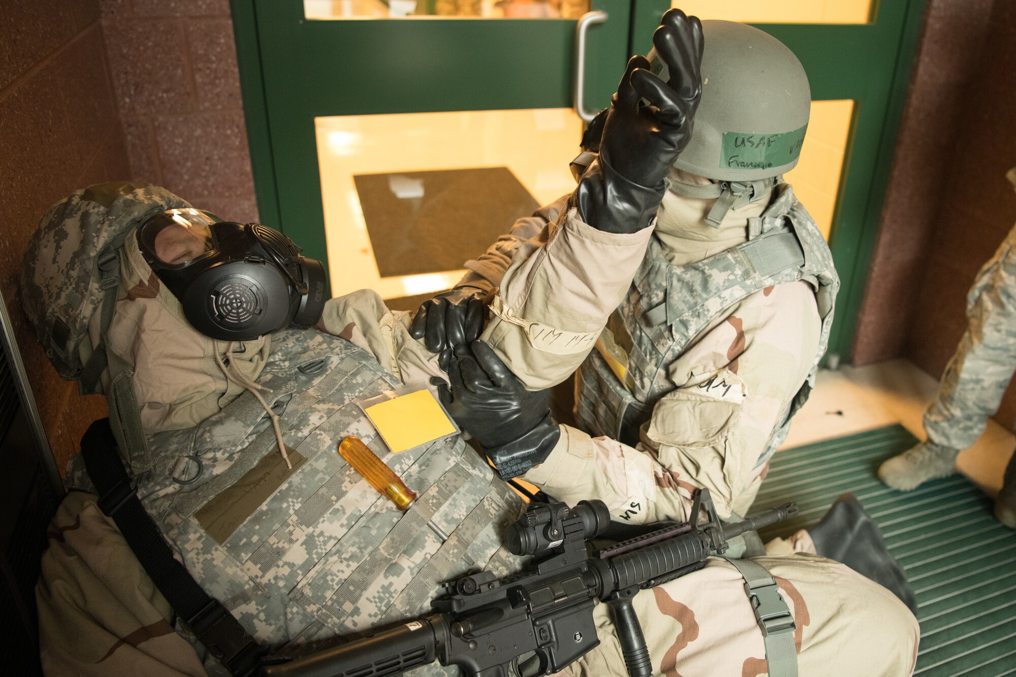 airmen in MOPP gear respond to a simulated medical emergency