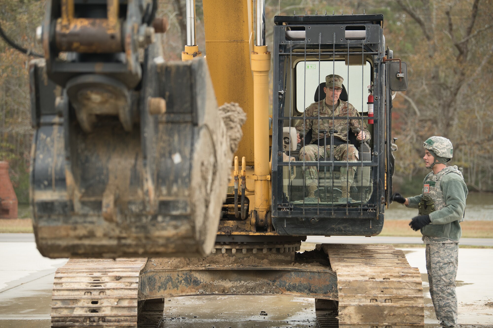 Airmen operate a backhoe