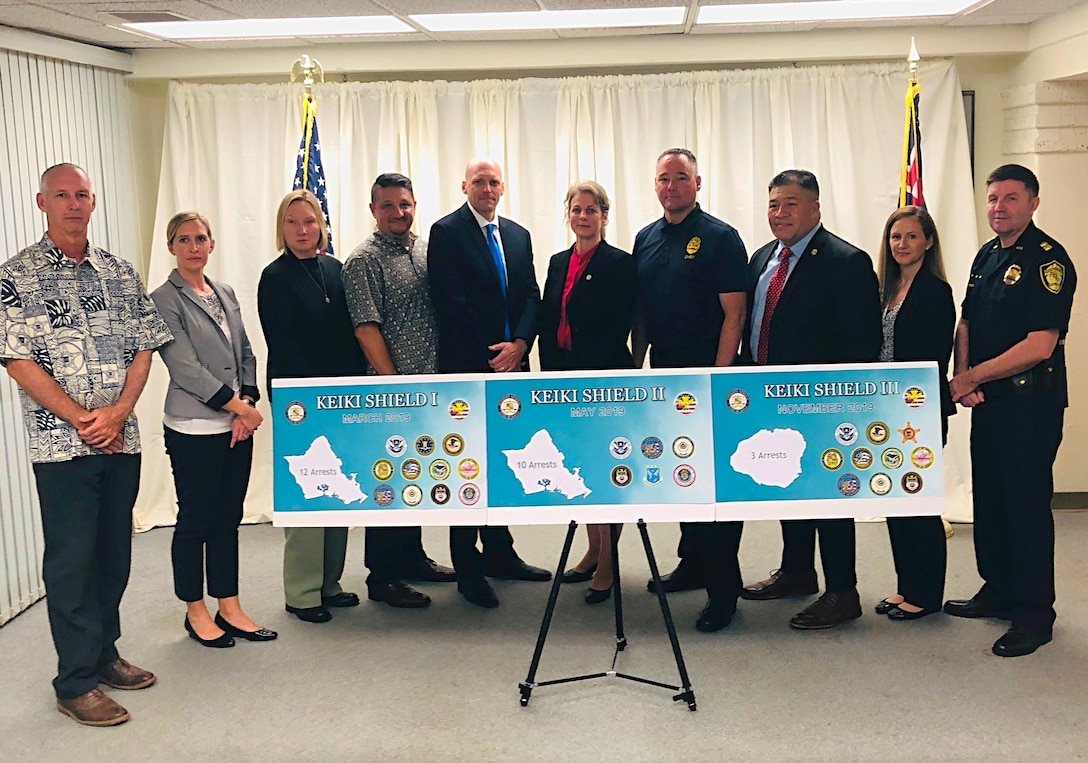 Law enforcement partners, including AFOSI Field Investigations Region 6 Commander, Col. Vasaga Tilo, Jr., third from right, and AFOSI Detachment 601 Commander, Lt. Col. Tasha E. Vick, second from left, pause during the Operation Keiki Shield news conference in Honolulu, Nov. 18, 2019. The media event centered on an unprecedented series of law enforcement operations in 2019 aimed at protecting Hawaii's keiki (children). (Photo courtesy Hawaii Attorney General's Office)