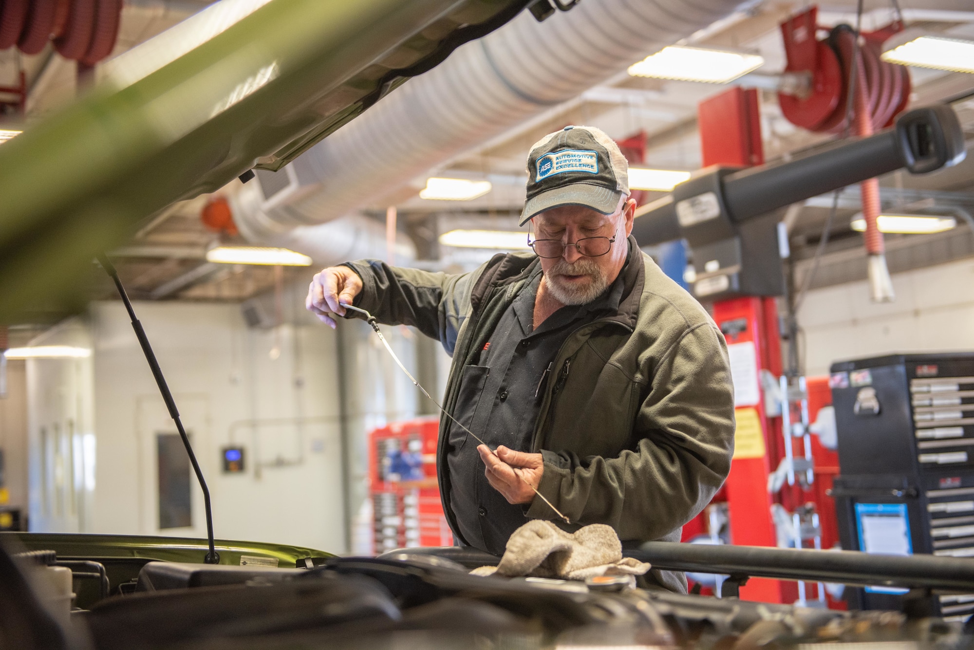 Billie Woods, 22nd Force Support Squadron Auto Shop mechanic, checks a vehicles oil levels Nov. 19, 2019, at McConnell Air Force Base, Kan. Woods inspected batteries, brakes, fluids, visors and lights then provided feedback and recommendations to less mechanically inclined drivers to give them confidence for the winter. (U.S. Air Force photo by Staff Sgt. Chris Thornbury)