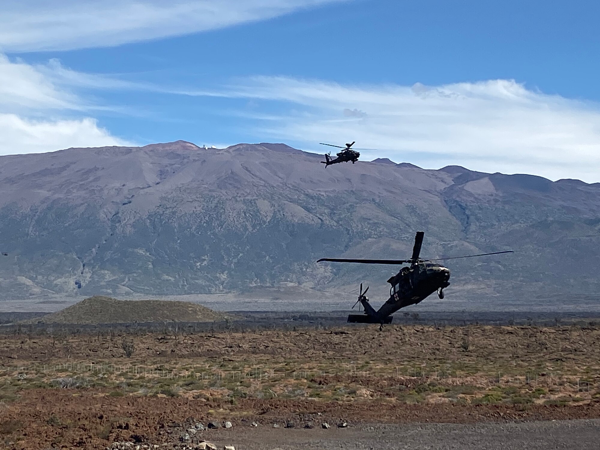 A UH-60 Black Hawk flares before landing with armed escort from an AH-64 Apache during infiltration operations for a Fire Support Coordination Exercise on Pohakuloa Training Area, located on the big island of Hawaii, November 12 through 21, 2019. During the exercise, members of the 25th Air Support Operations Squadron and U.S. Army Pacific 2nd Brigade, 25th Infantry Division, 2nd Brigade Combat Team, integrated with B-52 Stratofortress bombers for live-fire training missions in support of Indo-Pacific Command’s Continuous Bomber Presence operations. (Courtesy photo)