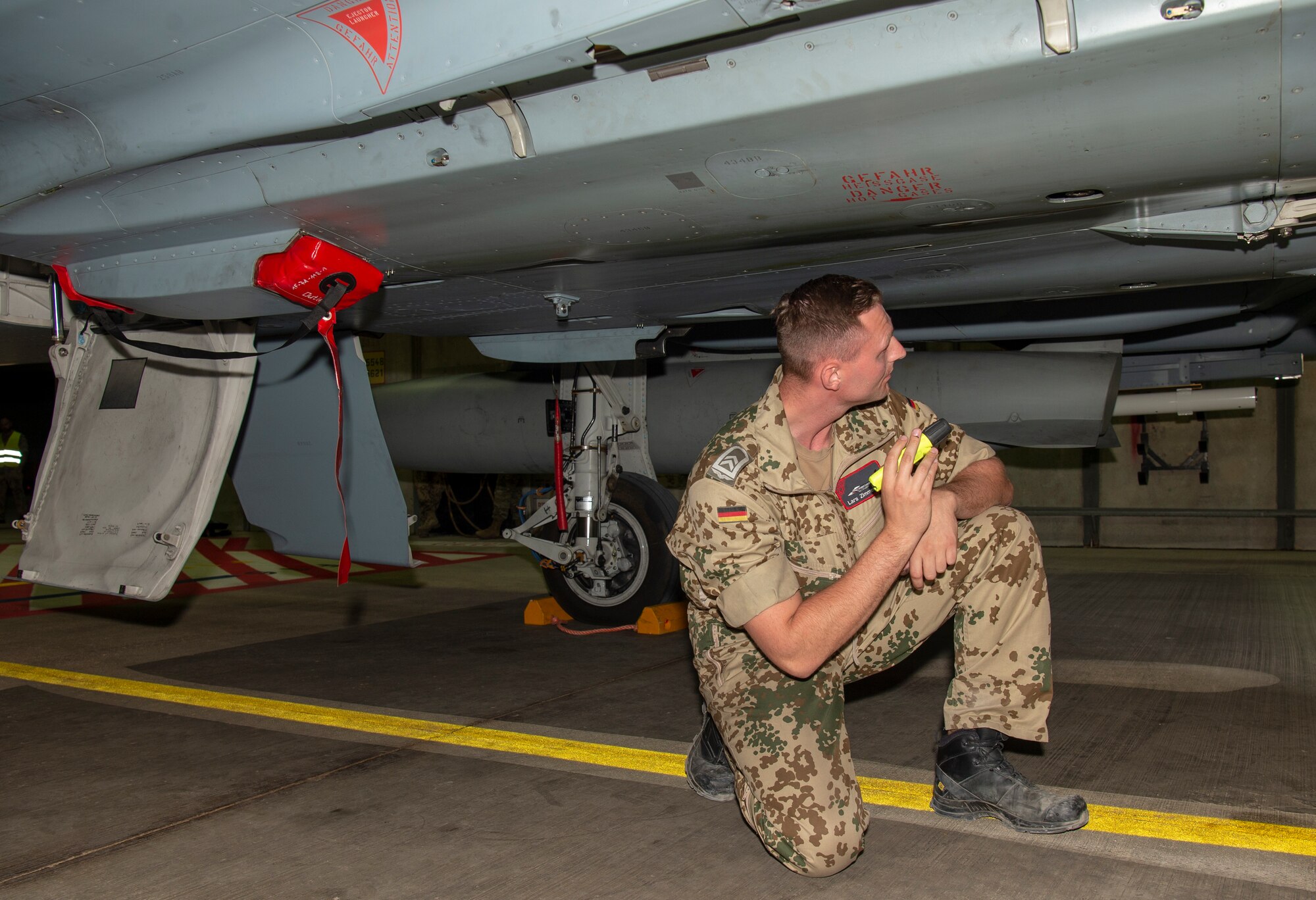 German air force Tech. Sgt. Lars Zimmerman, 71st Fighter Wing F-2000 Eurofighter Typhoon crew chief, inspects an F-2000 during Blue Flag 2019 at Uvda Air Base, Israel, November 11, 2019. The F-2000 is known as a four and a half generation fighter because it is a 4th generation platform that has upgraded systems. (U.S. Air Force photo by Airman 1st Class Kyle Cope)