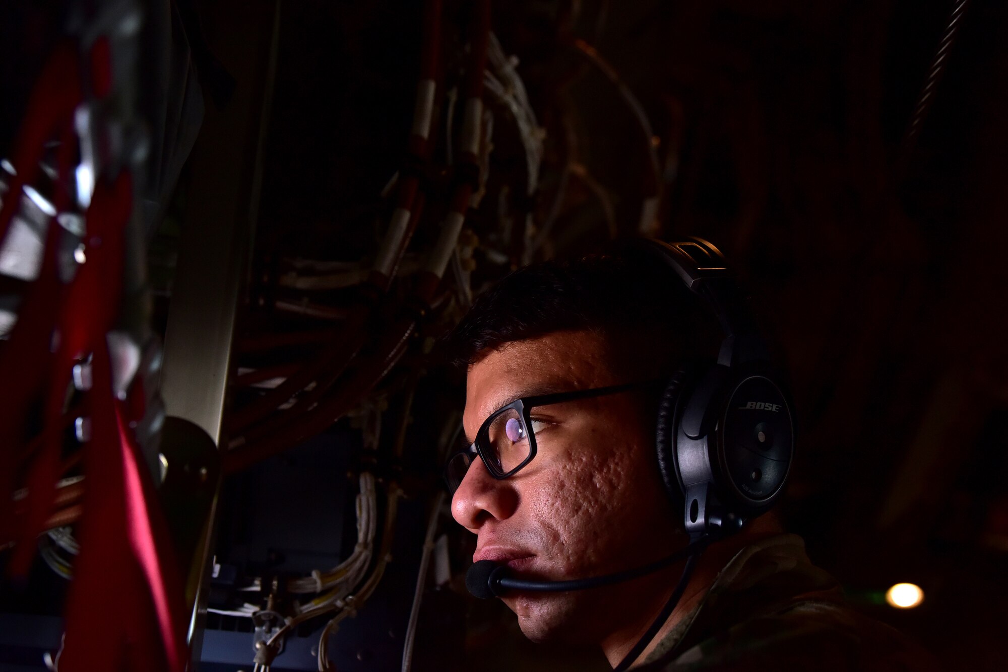 Personnel in uniform operate in and around an aircraft on an airfield