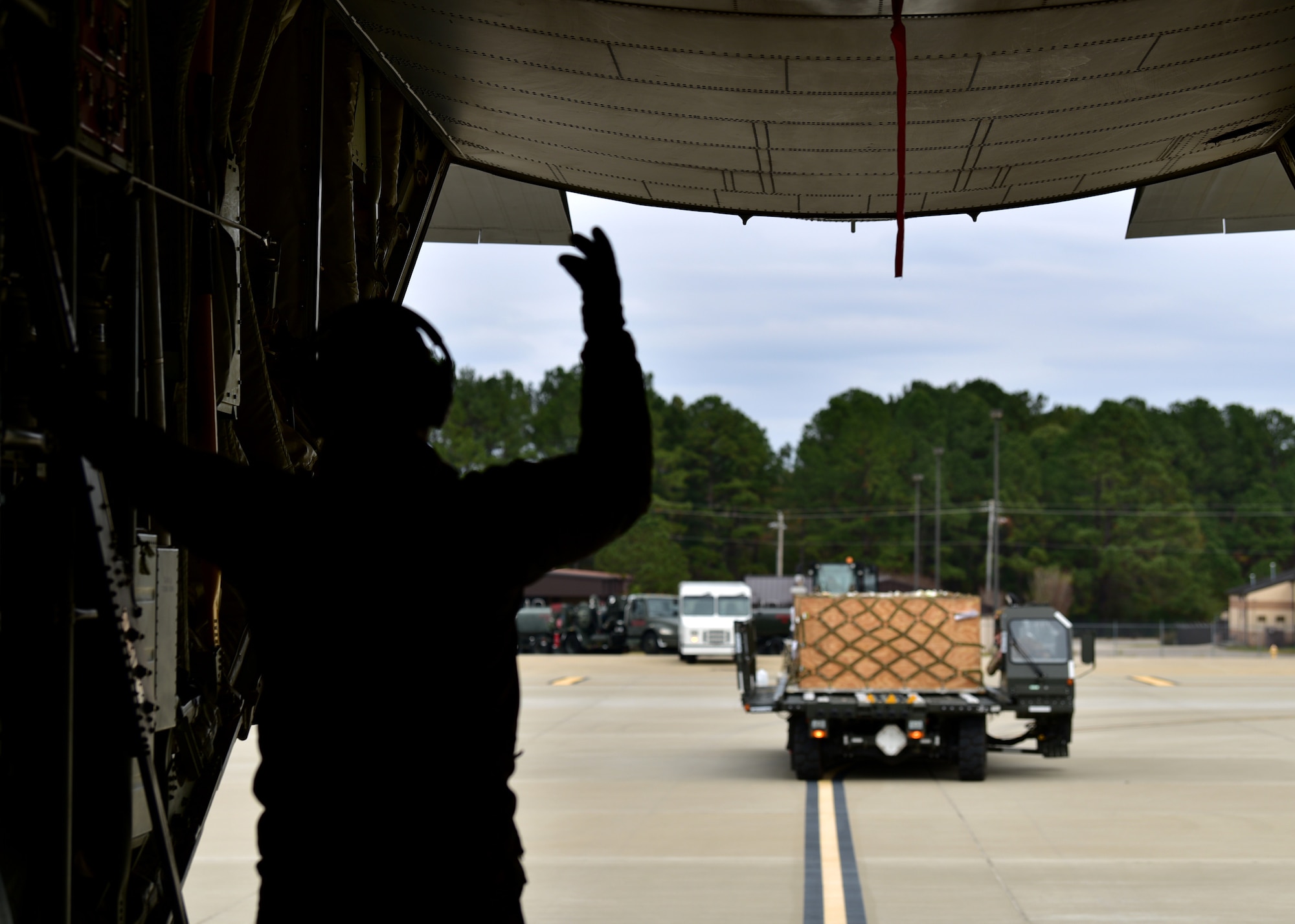 Personnel in uniform operate in and around an aircraft on an airfield