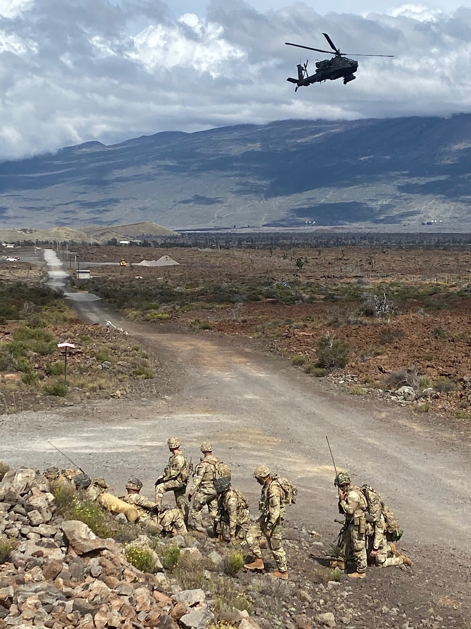 An AH-64 Apache provides armed over watch for Alpha Company during infiltration operations for a Fire Support Coordination Exercise on Pohakuloa Training Area, located on the big island of Hawaii, November 12 through 21, 2019. During the exercise, members of the 25th Air Support Operations Squadron and U.S. Army Pacific 2nd Brigade, 25th Infantry Division, 2nd Brigade Combat Team, integrated with B-52 Stratofortress bombers for live-fire training missions in support of Indo-Pacific Command’s Continuous Bomber Presence operations. (Courtesy photo)