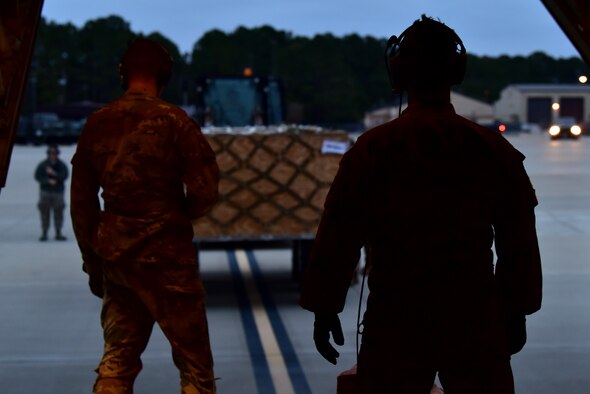 Personnel in uniform operate on an airfield and in an aircraft