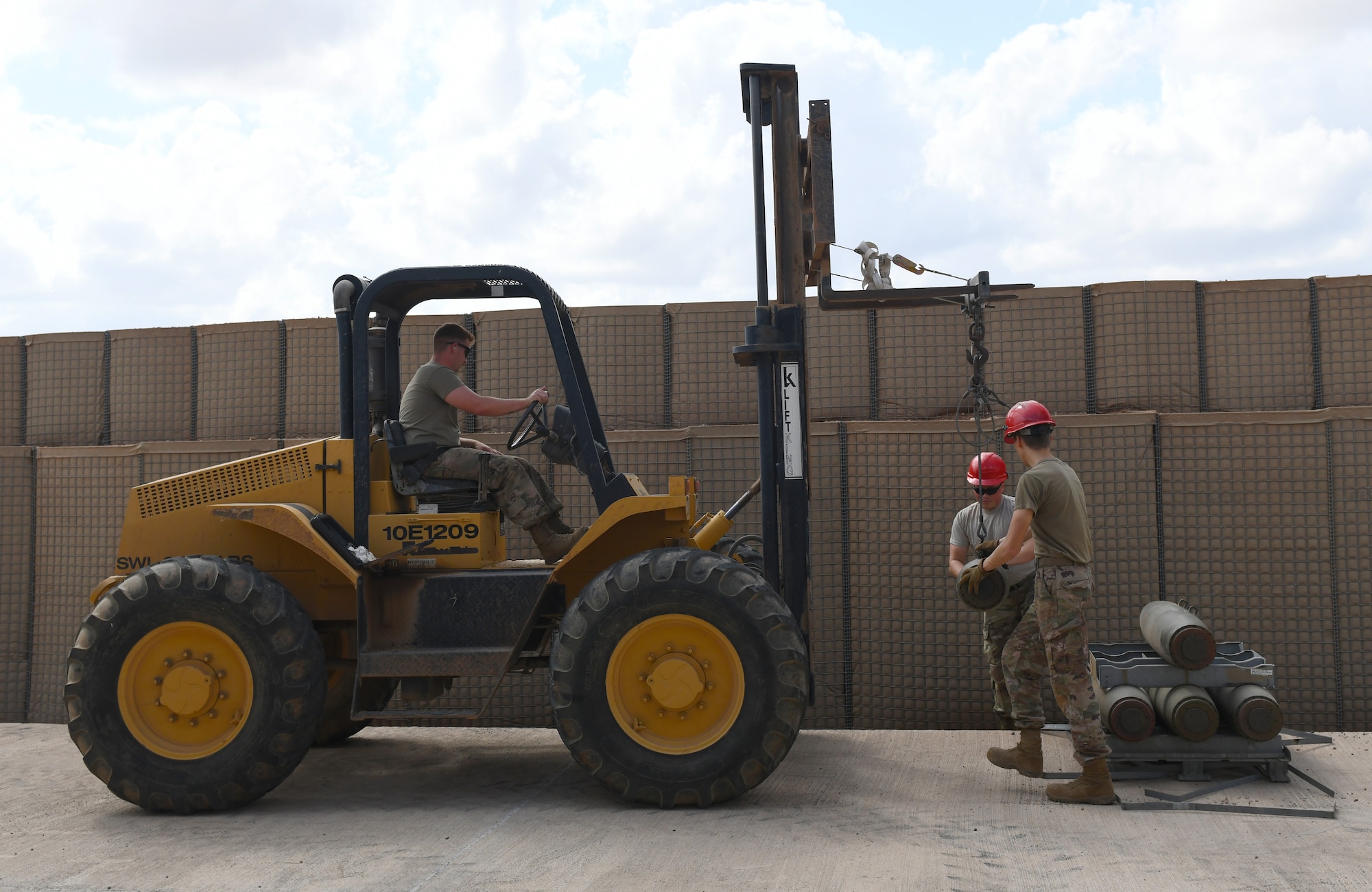U.S. Air Force munitions crew chiefs assigned to the 726th Expeditionary Air Base Squadron use a forklift to transfer munitions parts during a bomb build at Chabelley Airfield, Djibouti, Nov. 12, 2019. The 726th EABS Munitions Systems Airmen build, inspect and store all munitions at the airfield, ensuring mission effectiveness at a moment’s notice. (U.S. Air Force photo by Staff Sgt. Alex Fox Echols III)