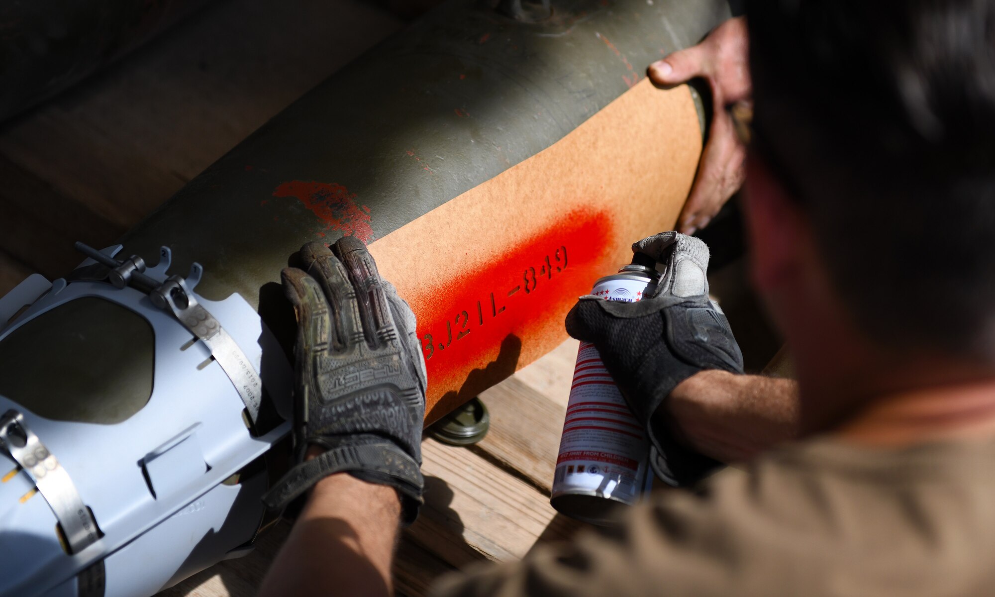 U.S. Air Force Tech. Sgt. Brandon Coleman, 726th Expeditionary Air Base Squadron munitions production supervisor, paints the identifier on munitions during a bomb build at Chabelley Airfield, Djibouti, Nov. 12, 2019. The 726th EABS Munitions Systems Airmen build, inspect and store all munitions at the airfield, ensuring mission effectiveness at a moment’s notice. (U.S. Air Force photo by Staff Sgt. Alex Fox Echols III)