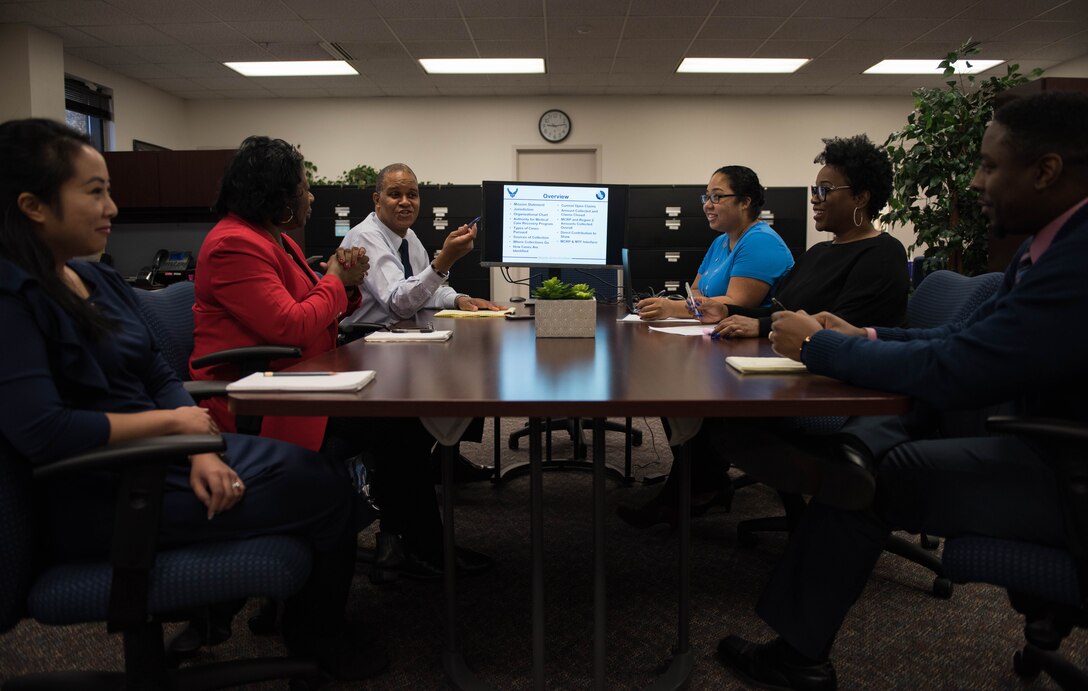 Team members of the Medical Cost Reimbursement Program discuss current cases at Joint Base Langley-Eustis, Virginia, Nov. 19, 2019. Types of cases include auto accidents, worker’s compensation, slip and falls, dog bites, product liability, medical malpractice and assaults. (U.S. Air Force photo by Airman 1st Class Sarah Dowe)