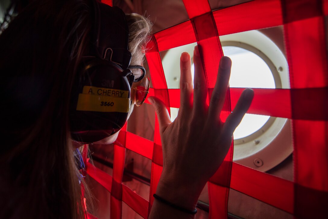 A photo of an attendee of the 347th Rescue Group spouses flight looking out the window of an HC-130J Combat King II