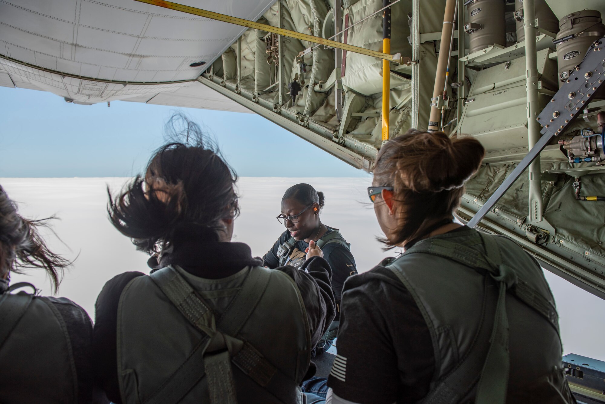A photo of attendees of the 347th Rescue Group spouses flight sitting on the ramp of an HC-130J Combat King II