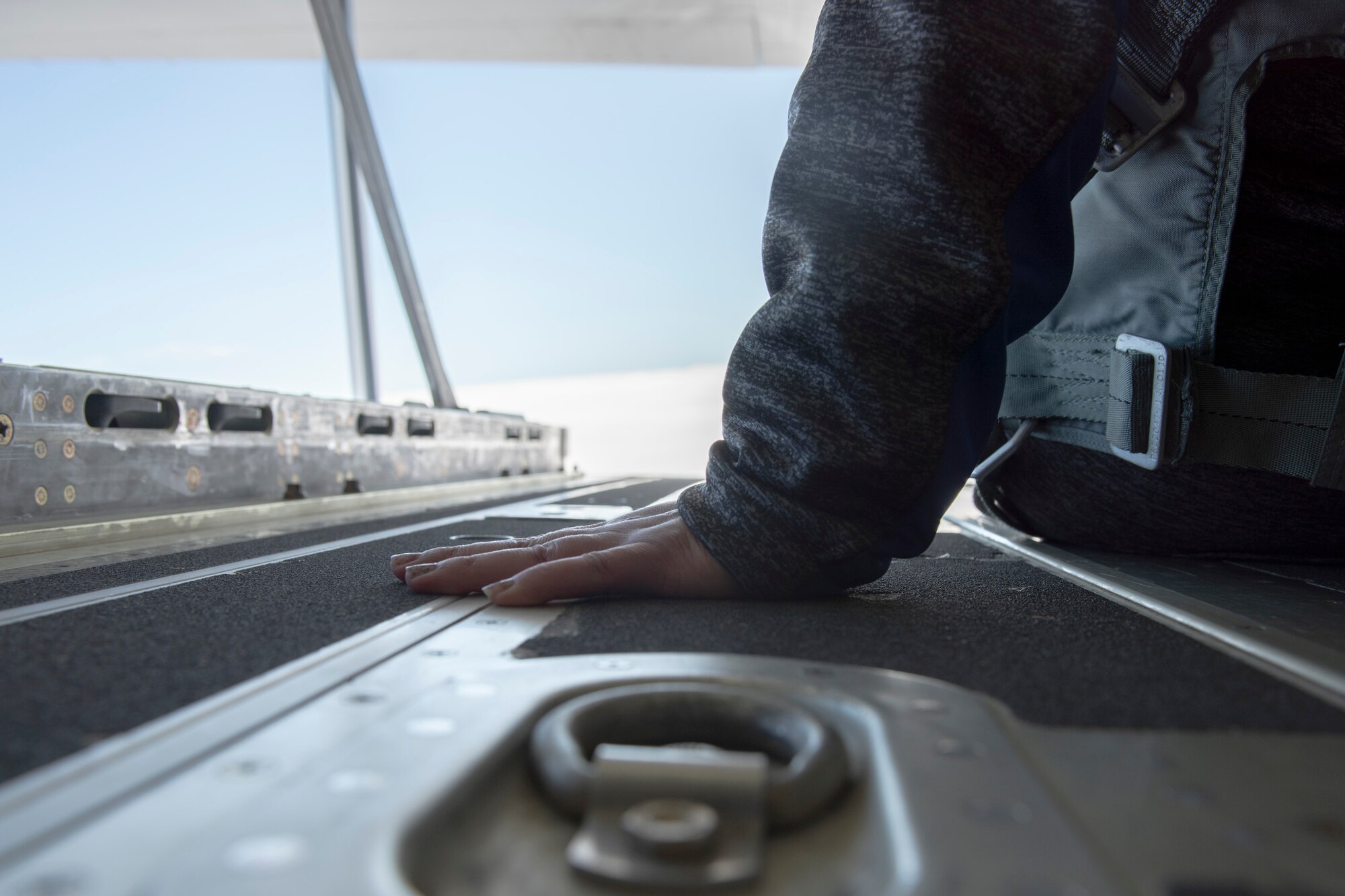 A photo of an attendee of the 347th Rescue Group spouses flight sitting on the ramp of an HC-130J Combat King II
