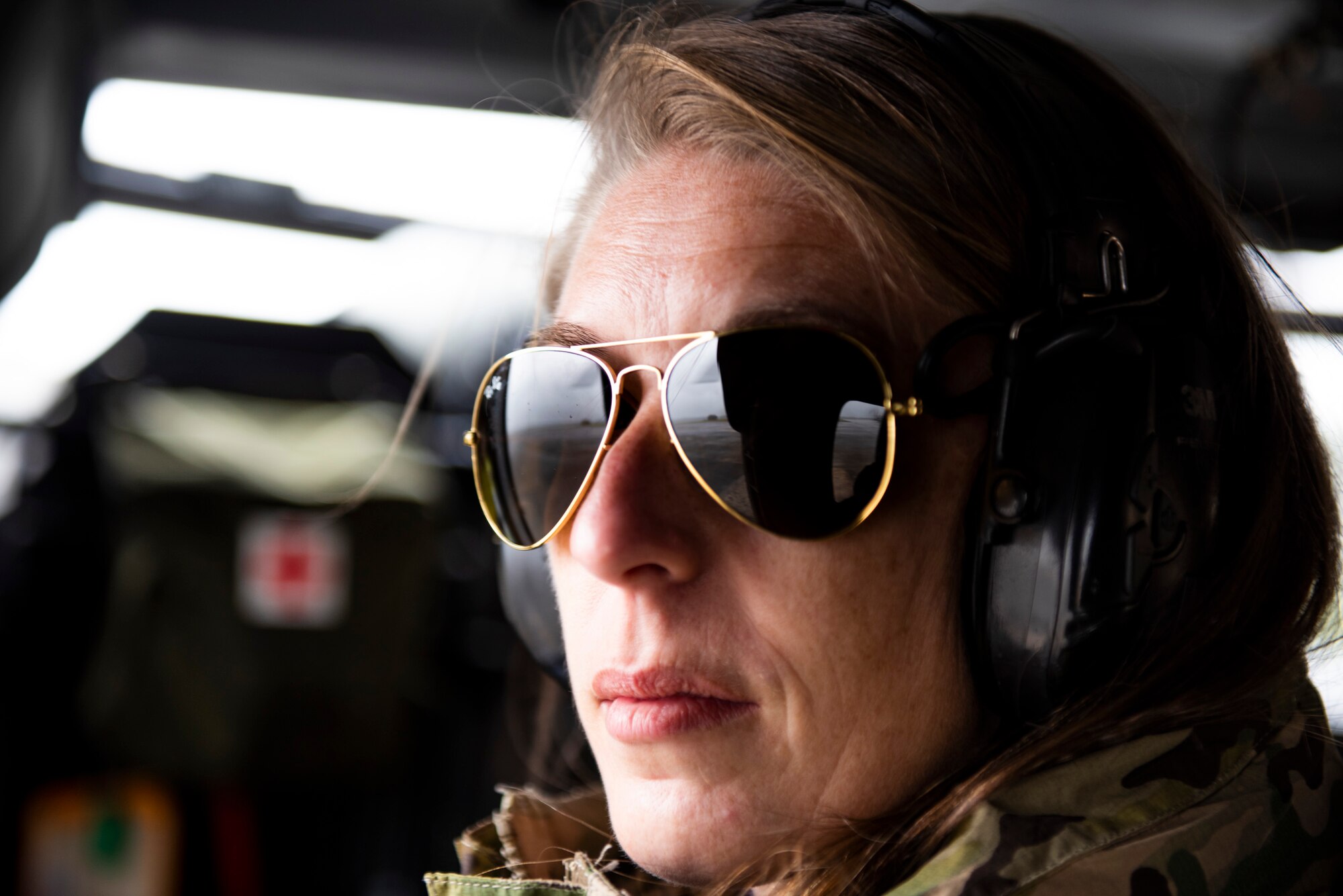 A photo of an attendee of the 347th Rescue Group spouses flight looking out of an HH-60G Pave Hawk