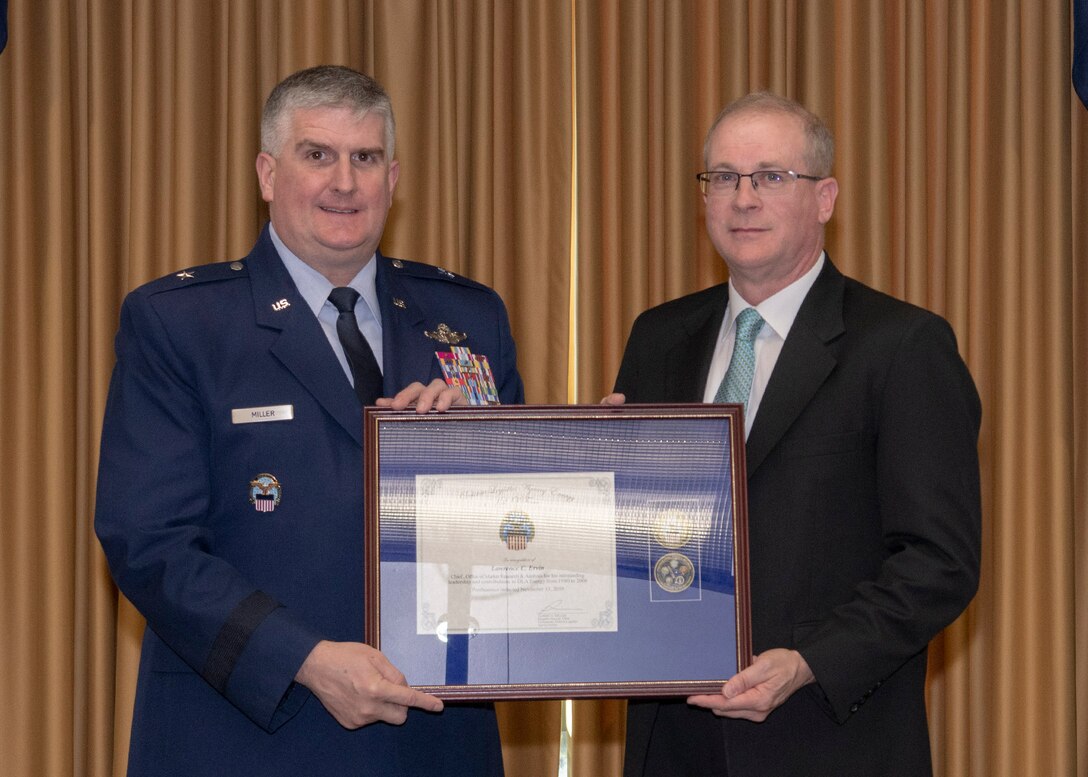 Two men hold a plaque