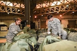 U.S. Air Force Senior Airman Santia Baker, left, and Senior Airman Ronald Tedder, 39th Logistics Readiness Squadron individual protective equipment specialists, sift through mobility bags Nov. 18, 2019, at Incirlik Air Base, Turkey. Because of the hazardous nature of some Air Force missions, IPE Airmen are responsible for providing life-saving gear to members across their installation. (U.S. Air Force photo by Staff Sgt. Joshua Magbanua)