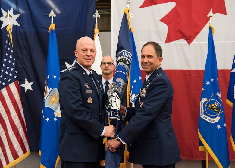 Gen. John W. “Jay” Raymond, U.S. Space Command and Air Force Space Command commander, presents the Combined Force Space Component Command guidon to Maj. Gen. John. E. Shaw, CFSCC and 14th AF commander, during a change of commander ceremony Nov. 20, 2019, at Vandenberg Air Force Base, Calif. The CFSCC mission is to plan, integrate, conduct, and assess global space operations in order to deliver combat relevant space capabilities to Combatant Commanders, Coalition partners, the Joint Force, and the Nation. (U.S. Air Force photo by Airman 1st Class Aubree Milks)