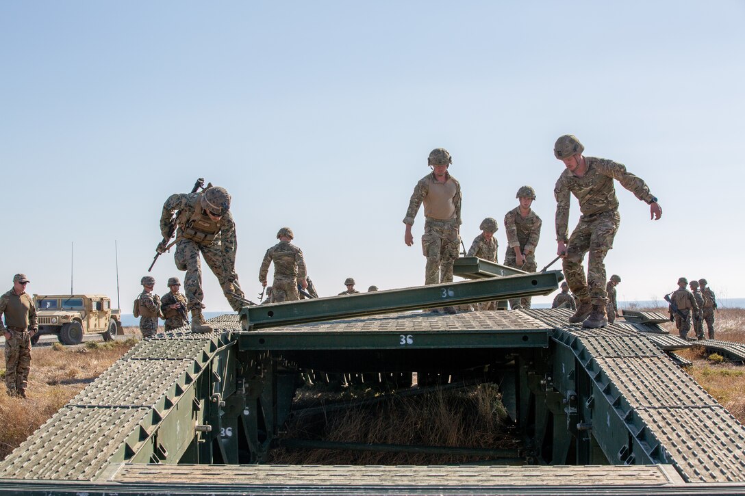 U.S. Marines with Bridge Company, 7th Engineer Support Battalion work with the Royal Marines to build a bridge.
